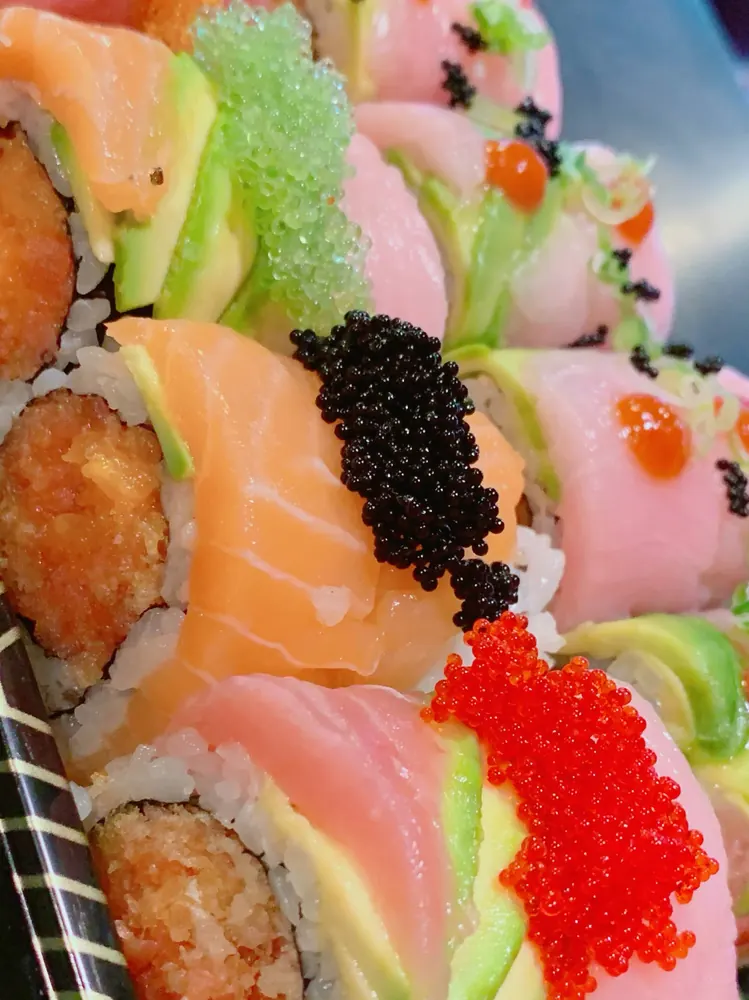 Close-up of salmon and tuna rolls topped with tobiko